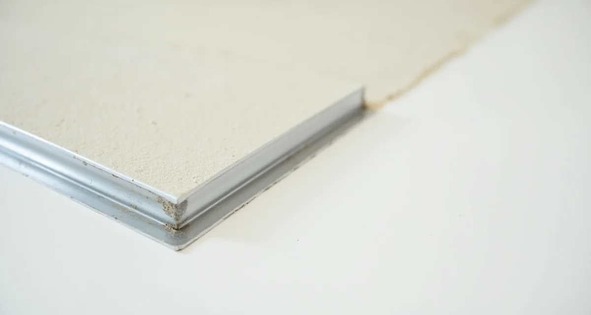 Prossimo dettaglio di un paraspigolo metallico installato su cartongesso con stucco bianco